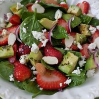 Špinačna solata z jagodami, avokadom, feta sirom in medeno makovim prelivom